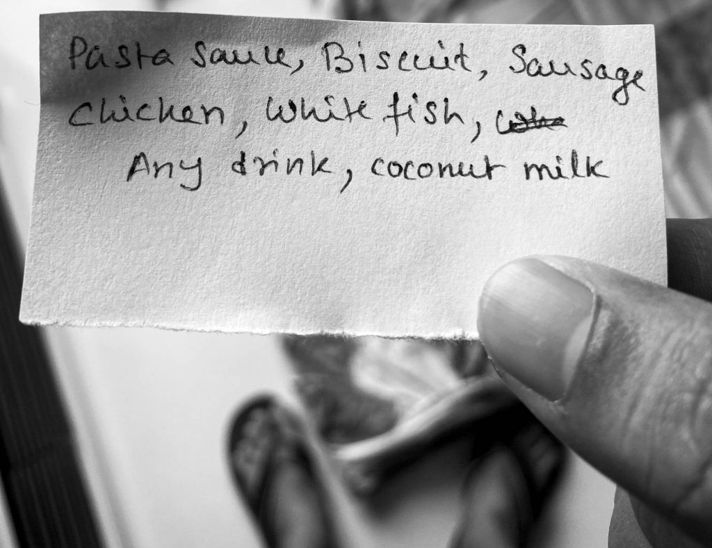 Writing grocery list on a piece of paper to avoid taking out phone from pocket