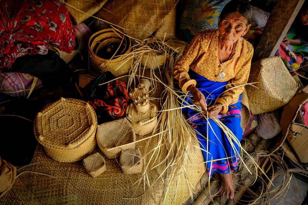 An old lady weaves basket in Sumba, Indonesia