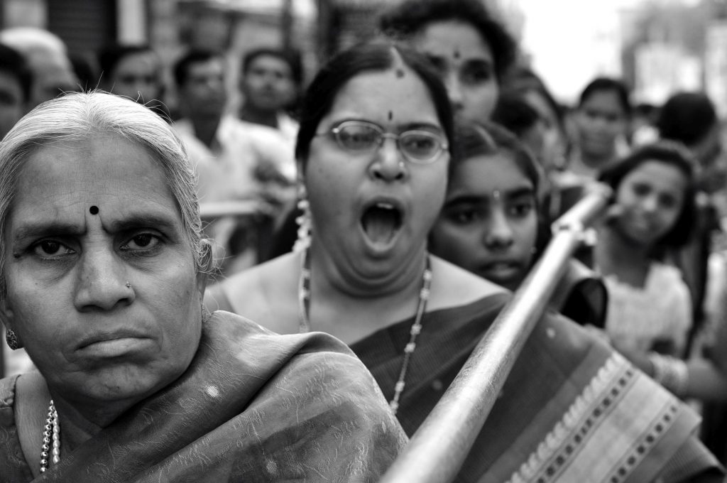 A woman is seen as she yawns while waiting in a long queue outside the temple.