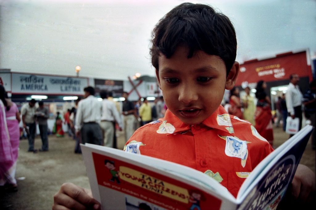 Defying the electronic media, the internet and the cyber-world, the tiny-tots pour over children's volume, inhaling their fresh smell, appreciating their get-up.