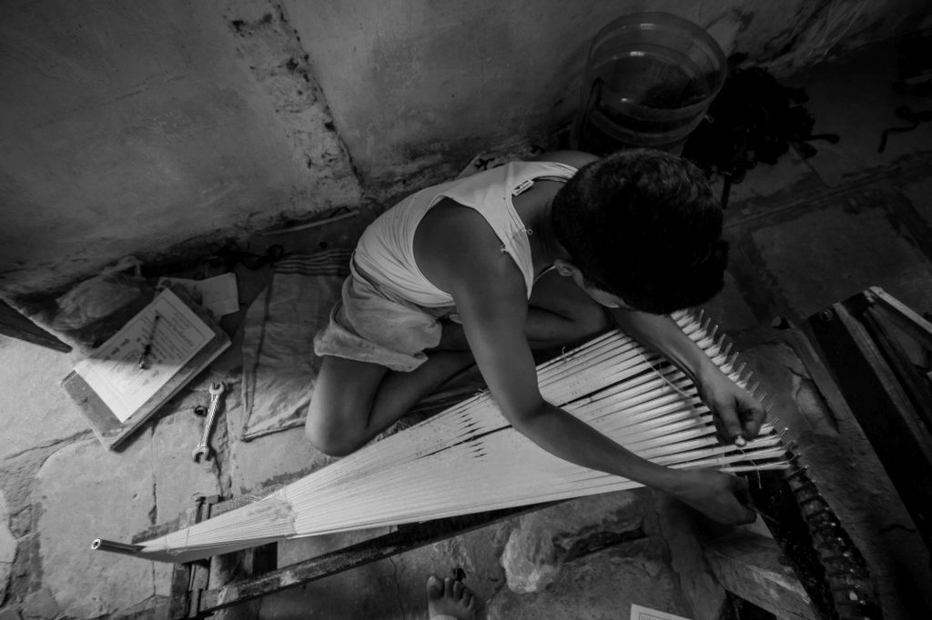 A young worker is seen as he marks the cotton yarns before sending for dyeing
