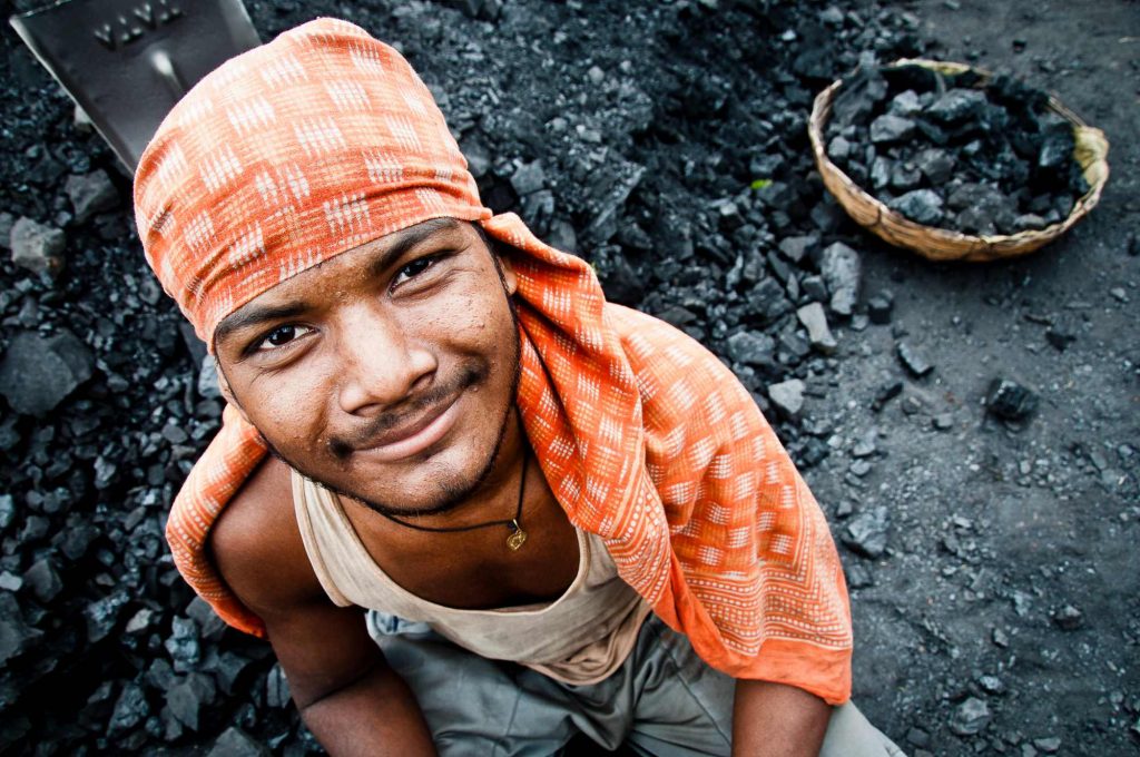 A worker working at the factory who keep supplying coals into the furnace